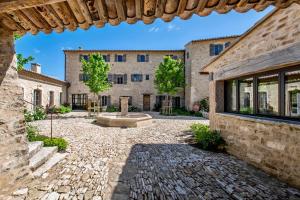 an external view of a building with a fountain in a courtyard at La Bastide de Clara in Oppède