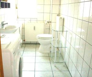 ein weißes Badezimmer mit Toilette und Waschbecken in der Unterkunft Ferienhaus "Oste-Anker" mit Sauna, Kaminofen und viel Platz für die Familie in ruhiger Lage in Oberndorf