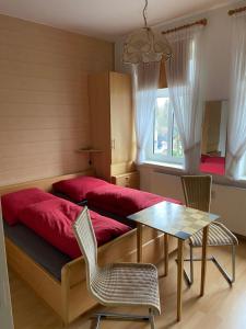 a bedroom with a red bed with a table and chairs at Kleine Stranddüne in Cuxhaven
