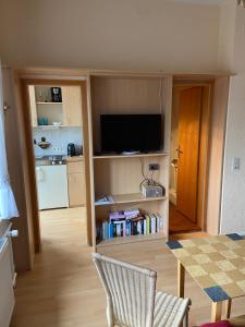 a living room with a television and a table with chairs at Kleine Stranddüne in Cuxhaven