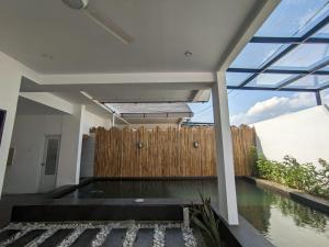 a house with a swimming pool and a wooden fence at Villa Bambu Batam in Bokor