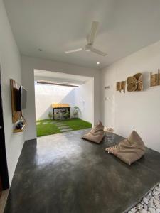 a living room with a ceiling fan and a table at Villa Bambu Batam in Bokor