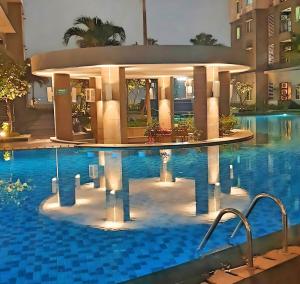 a hotel swimming pool with a building in the background at Strategic 3BR Thamrin Residence Near Pl & GI by 2ndHome in Jakarta