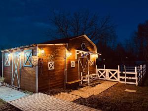 a small wooden cabin with lights on it at night at Arany Vendégház in Szarvas