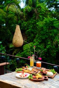 a table with plates of food and drinks on it at Vije Boutique Resort & Spa in Ubud