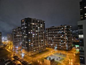 a view of a city at night with tall buildings at Трендова квартира з комфортом готелю у топовому ЖК Києва in Kyiv