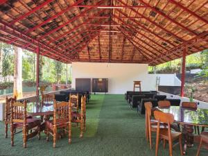 comedor con mesas y sillas y un gran techo en vintage Valley's Riders Dormitory, en Thodupuzha