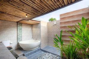 a bathroom with a bath tub and a sink at Reynten Hill in Nusa Penida
