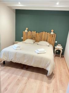 a bedroom with a large bed with two towels on it at Gîte in Saint-Bénigne +23 photos