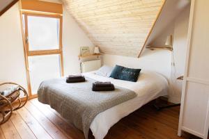 a bedroom with a bed with two towels on it at Ty Glaz Lilia - La maison bleue in Plouguerneau