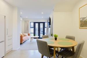 a dining room and living room with a table and chairs at Modern Townhouse, Prime Location, Carpark in Christchurch