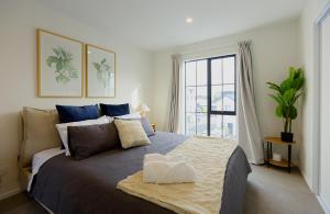 a bedroom with a large bed and a window at Modern Townhouse, Prime Location, Carpark in Christchurch