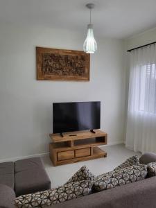 a living room with a couch and a flat screen tv at Elegant 1 bedroom apartment with close amenities in Quatre Bornes