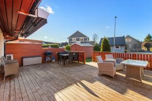 a wooden deck with chairs and a table on it at Hus i Verdal med 3 soverom in Verdal +1 photo