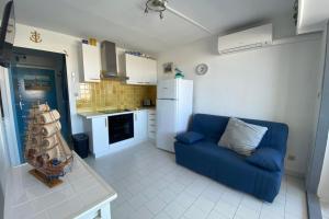 ein Wohnzimmer mit einer blauen Couch in einer Küche in der Unterkunft Softness of the shore on the port side in Frontignan
