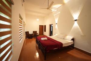 a bedroom with a bed with a red blanket at Chandralayam Heritage Homestay in Bekal