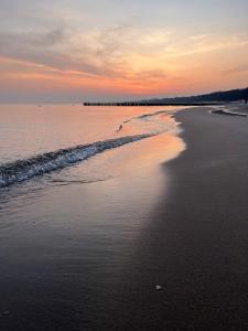 a view of the beach at sunset at LIKE APARTMENT in Kołobrzeg