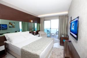 a hotel room with a large bed and a television at Faustina Hotel & Spa in Güzelçamlı
