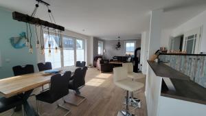 een eetkamer en woonkamer met een tafel en stoelen bij Ferienhaus Heimathafen Dranske in Dranske +11 foto's