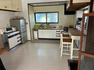 a kitchen with white cabinets and stainless steel appliances at fuga貸別荘 in Tateyama