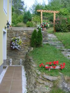 a stone retaining wall with flowers in a yard at Kolarnock in Feld am See