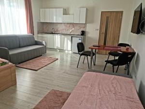 a living room with a couch and a table and chairs at Comenius Apartments - Apartmány na rohu in Svidník