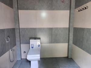 un baño con inodoro y ducha en vintage Valley's Riders Dormitory, en Thodupuzha