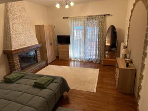 a living room with a bed and a fireplace at Οικία τζιβαέρι in Edessa