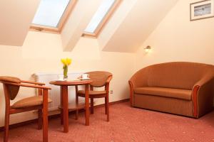 a room with a couch and a table and a chair at Bursztyn in Niechorze