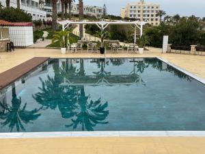 a large swimming pool with blue water at Vrachia Beach Hotel & Suites - Adults Only in Paphos