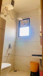 a bathroom with a toilet and a window at The Grand's in Jagādhri