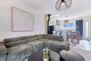 un salon avec un canapé et une cuisine dans l'établissement Les Embruns du Clos - A 1 km des rives de la Seine, à Berville-sur-Mer