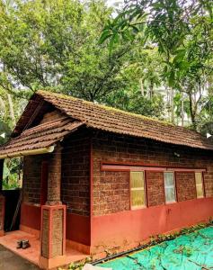 a small brick house with a pool in front of it at Chandralayam Heritage Homestay in Bekal