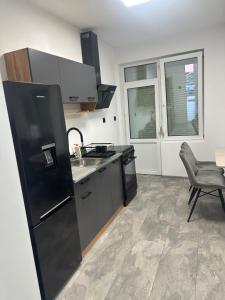 Una cocina con un refrigerador negro y un fregadero. en Best places, en Petrich