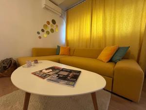 a living room with a couch and a table at Serelor Cozy Flat in Dumbrăviţa