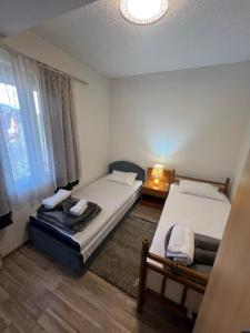 a room with two beds and a window at Milić apartmani 2 in Kuršumlija