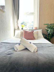 two beds with pillows on them in a bedroom at The Bournemouth Hideaway - Beautiful Central flat - 10 mins walk to beach - Brought to you by Coastline Retreats in Bournemouth
