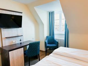 a hotel room with a desk and two chairs at Hotel & Gästehaus Seehof in Meersburg