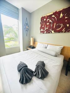 Un dormitorio con una cama blanca con toallas. en Cozy apartment Karon, en Phuket