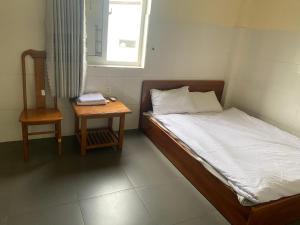 una piccola camera da letto con un letto e un tavolo di nhà nghỉ thu hiền a Buôn Ma Thuột