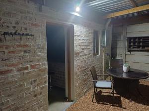 a room with a table and a brick wall at 7th Heaven Guest Cottage in Paarl +2 photos
