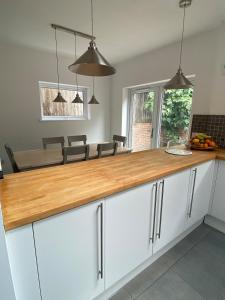 a kitchen with white cabinets and a wooden counter top at 4 Bedroom Detached House Sleeps 7 in Ipswich