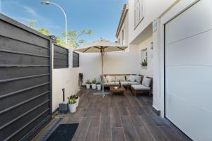 a patio with a couch and an umbrella at Casa el Jable in Guía de Isora