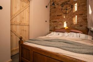 a bedroom with a bed with a brick wall at Kamienica Marianna in Reszel
