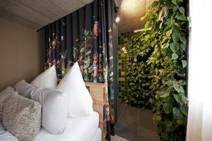 a bedroom with a wall of green plants at die Träumerei GmbH in Michelstadt