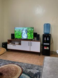ナイロビにあるGrey Airbnbのリビングルーム(白いキャビネット、薄型テレビ付) +2枚の写真