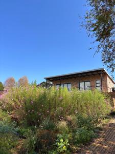a brick house with a garden in front of it at Mika Self Catering Cottage in Dullstroom