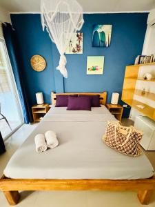 a bedroom with a large bed with two towels on it at Nautilus Hostel & Hammocks in Panglao +60 photos
