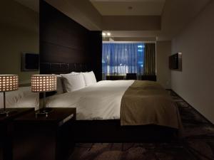 a bedroom with a large bed with a large window at Akasaka Granbell Hotel in Tokyo