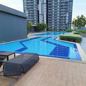 una gran piscina con sillas y edificios en Lisa Sensory Residence, en Kampung Dengkil